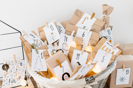Advent calendar waiting for Christmas. Basket with envelopes with numbers and tasks for children standing on cabinetの写真素材