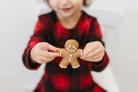 Little girl holding homemade ginger man cookies. Christmas timeの写真素材