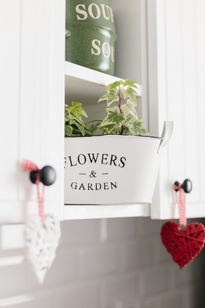 Heart shape decoration hanging on white kitchen cabinets close up kitchen details. Decorate your kitchen with loveの写真素材
