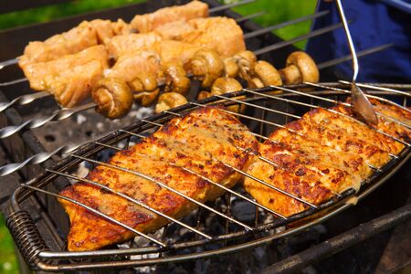 Grilled salmon steaks on the grill.Portobello mushrooms marinated and grilling close up.の写真素材