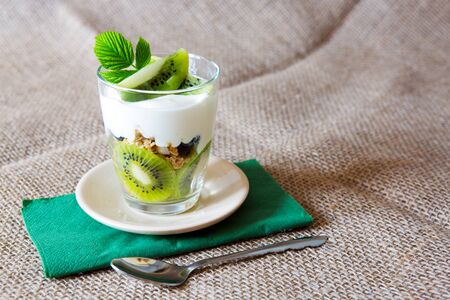 Fresh Yogurt with kiwi isolated on brown cloth background.の写真素材