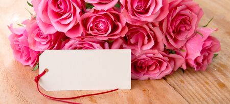 Mothers day greeting card or photo frame and pink rose over wooden table.の写真素材