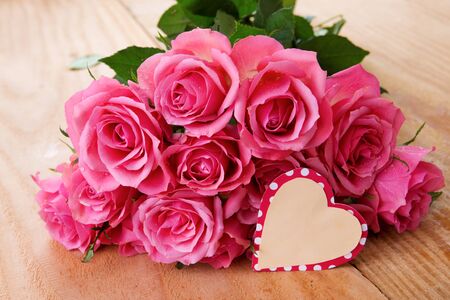 Mothers day greeting card or photo frame and pink rose over wooden table.の写真素材