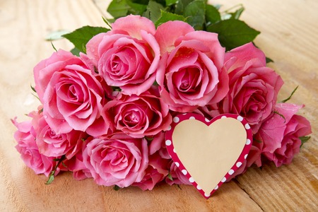 Mothers day greeting card or photo frame and pink rose over wooden table.の写真素材