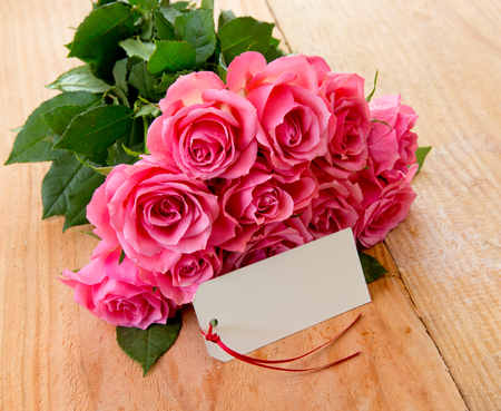 Mothers day greeting card or photo frame and pink rose over wooden table.の写真素材