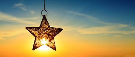 Bright christmas star and sunset. Christmas background.の写真素材