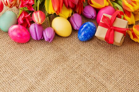 Spring tulips with colorful easter eggs and gift box.