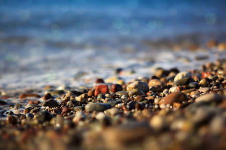 Waves washing over gravel beach, macro shot.
