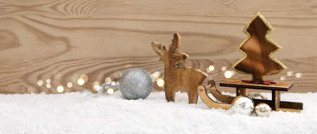 Christmas background with wood deer and fir-tree on sledge.の写真素材