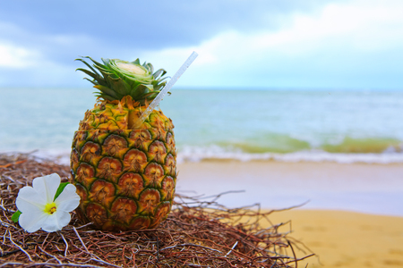 Tropical pineapple cocktail drink at the caribbean beachの写真素材