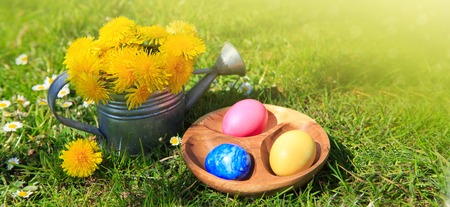 Easter eggs and watering can with flowers. Easter background.の写真素材