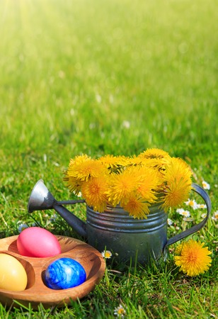 Easter eggs and watering can with flowers. Easter background.の写真素材