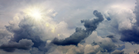 Gray rainy sky with big clouds and sunset.