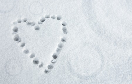 Valentines Day heart written at the white snow background .