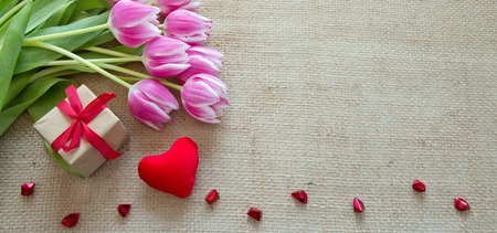 Tulips and red heart on brown cloth Background.の写真素材