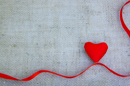Red heart and ribbon isolated on gray cloth background.の写真素材