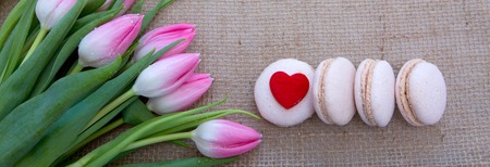Mothers day background with tulips bouquet and pink macarons.の写真素材