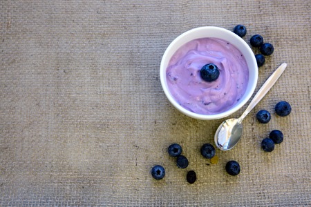 Yogurt with blueberry in a bowl isolated on a cloth background.の写真素材