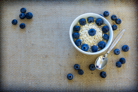 Yogurt wit hoatmeal and blueberry in a bowl isolated on a cloth background.の写真素材