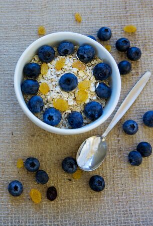 Yogurt wit hoatmeal and blueberry in a bowl isolated on a cloth background.の写真素材