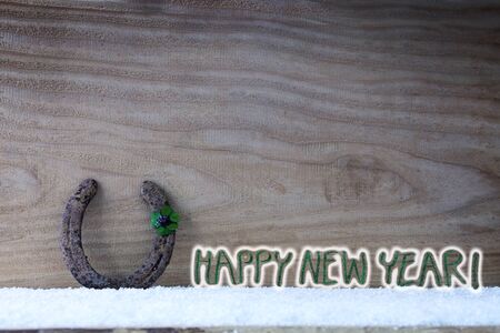 Horseshoe four leaf clover on wood. New year background.