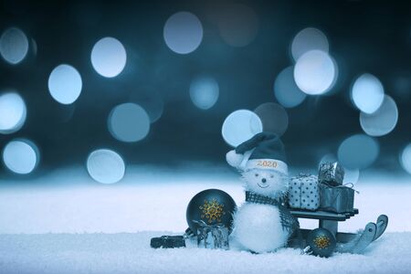 New Year 2020. Snowman with santa claus hat on snow .