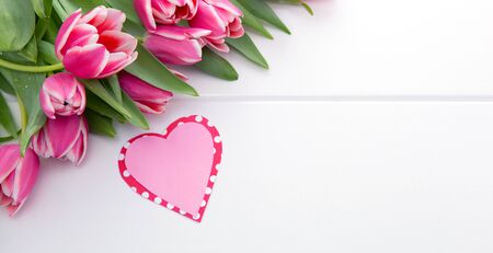 Vlentines Day heart and a bouquet of beautiful tulips on wooden background.の写真素材