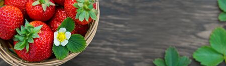 Strawberries in basket on wooden background.の写真素材