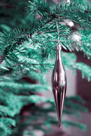 Golden Christmas icicle isolated on gray bokeh holiday light backgroundの写真素材