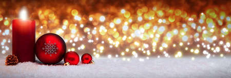 Christmas background with Advent candle and red decoration.の写真素材