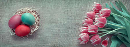 Easter eggs in the nest and pink tulips.