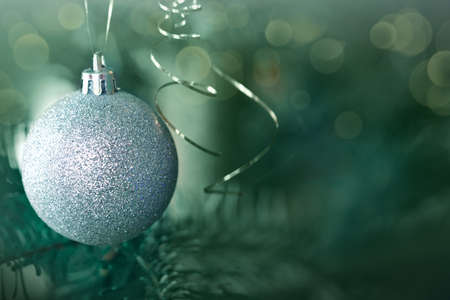 Christmas gray ball hanging on pine branches with festive backgroundの写真素材