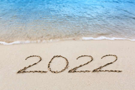 New Year 2022 written at the caribbean sand beach with sea wave .の写真素材