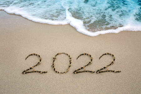 New Year 2022 written at the caribbean sand beach with sea wave .の写真素材