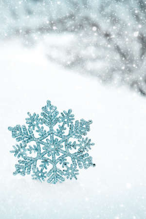 Christmas background with blue snowflake on white snow.の写真素材