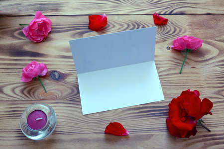 Red and pink roses on brown wooden background. Birthday card.の写真素材