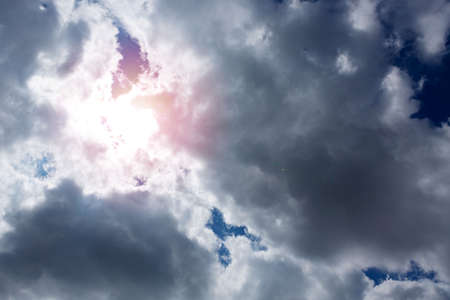 Blue sky with sun and beautiful gray clouds.の写真素材