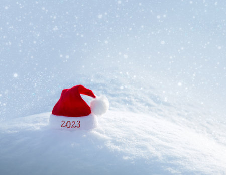 New year 2023 background with red Santa hat on white snow.の写真素材