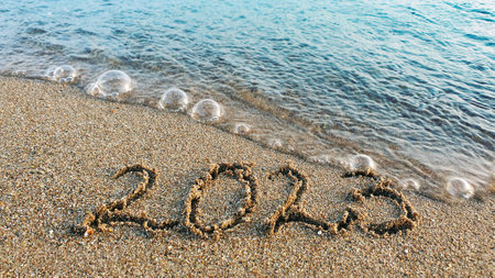 New year 2023 handwritten in the sand surface