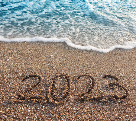 New year 2023 handwritten in the sand surface