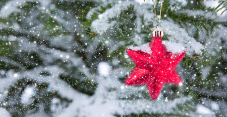 Red star on snow covered pine branch .Christmas background.の写真素材