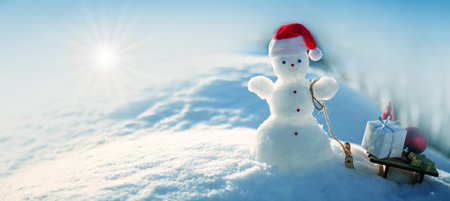 Christmas background with snowman and gifts stand in white snow.の写真素材