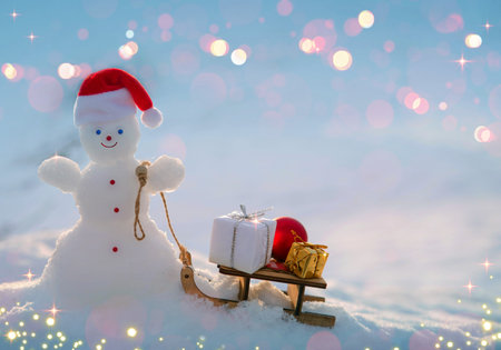 Christmas background with happy snowman and wood sled, stand in white snow.の写真素材