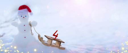 Fourth Advent. Snowman and wood sled, stand in white snow.の写真素材