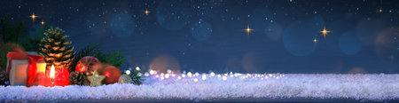 Red Advent candle with Christmas decorations isolated on blue bokeh background.の写真素材