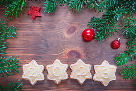 New Year background with decorations and 2023 cookies on wooden boardの写真素材