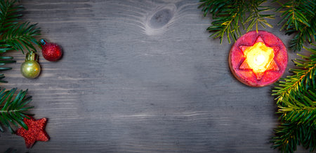 Christmas background with decorations and red candle on wooden boardの写真素材