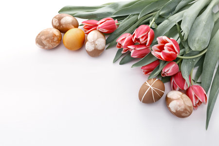 Easter background with bouquet of pink tulips and colorful eggs .の写真素材