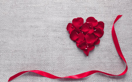 Red heart of roses petals isolated on a cloth background.の写真素材