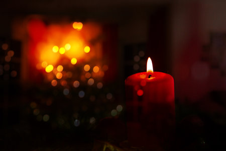 Glowing Advent candle and fireplace in blurred backgroundの写真素材